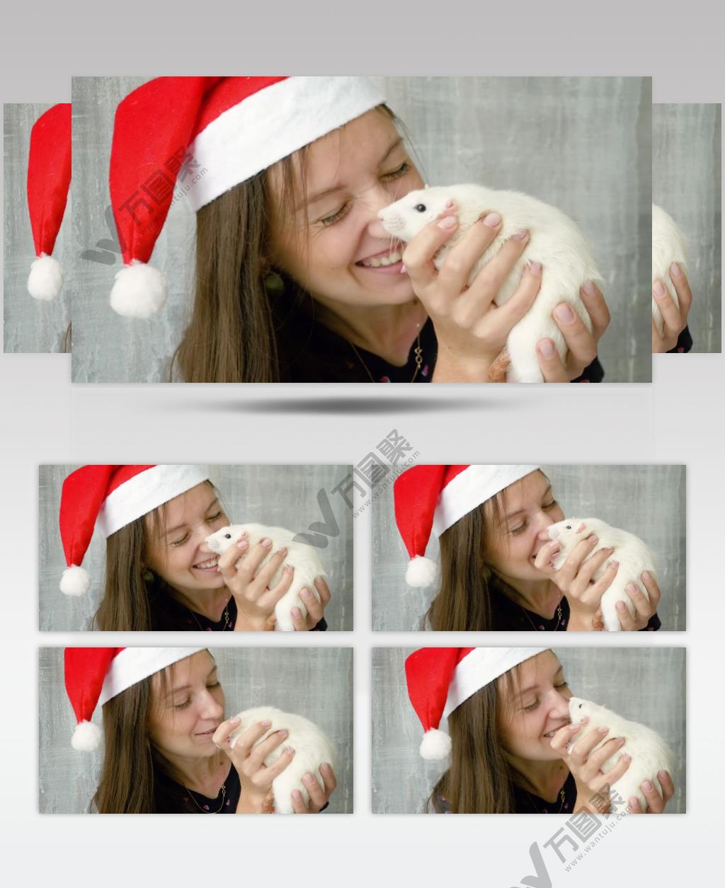 女生戴着圣诞帽抱着一只小白鼠