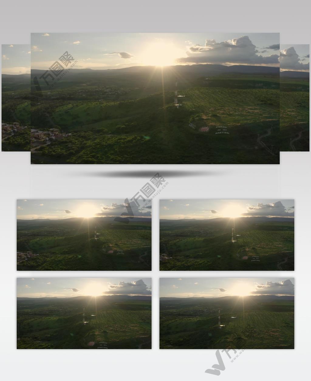 航拍草地的高原覆盖着草地树木一个小镇和日落时地平线上的群山