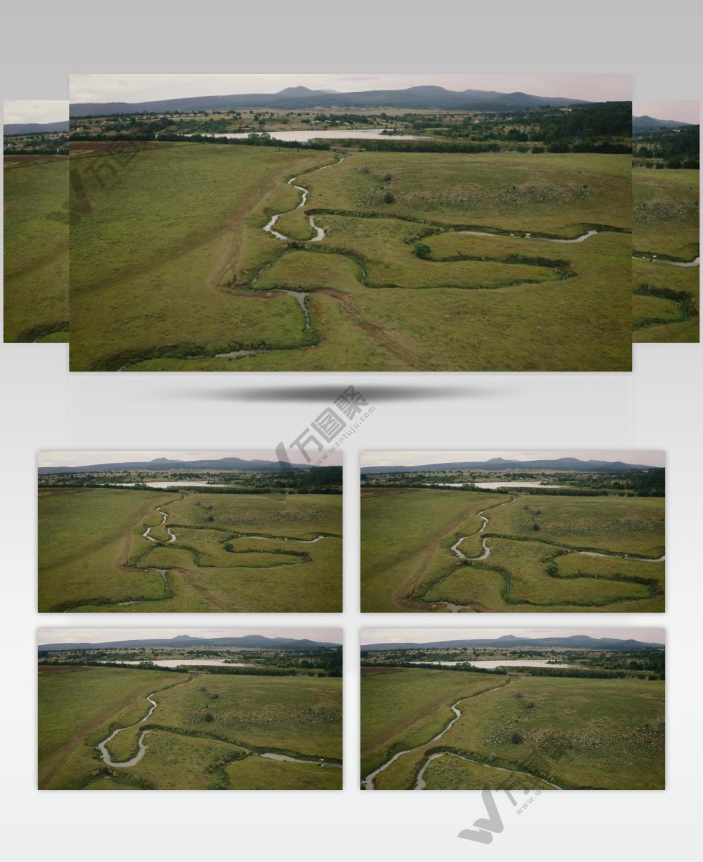 航拍绿色的河流田野和远处山脉背景下的湖泊