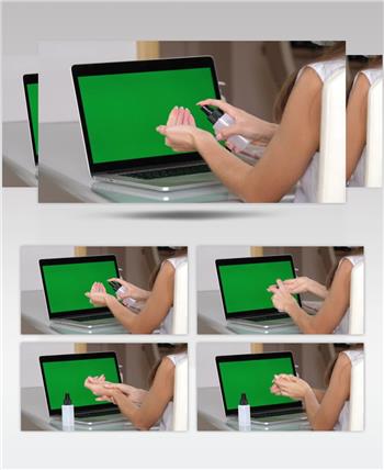 在绿幕电脑前女人用洗手液消毒