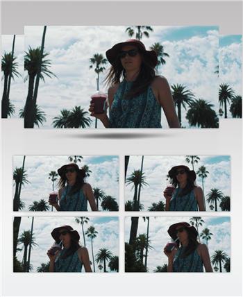 一个女孩在阳光明媚的夏日走在大街上，喝着冰镇的饮料