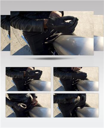 一个穿着黑色皮夹克和黑色皮裤的人坐在静电摩托车上，戴着黑色皮手套