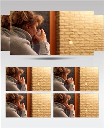 从一个小杯子里正在喝茶的女人