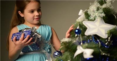 旁边小女孩摸着一棵圣诞树