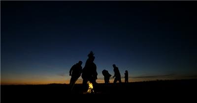 实拍一群旅游露营伙伴在黑夜中围着篱火跳舞开心