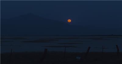 夜晚，在平坦的沙漠中，望向地平线，满月闪烁着鲜红的光芒。