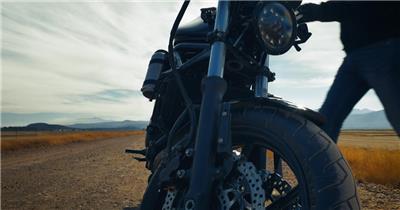 旅游爱好者骑着停在沙漠中的摩托车