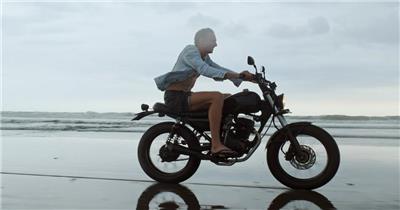 在海滩上骑摩托车男子