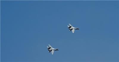  航拍穿过蓝天的军用战斗机训练飞行