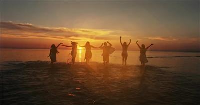 日落夕阳下一群美女在海边跳舞