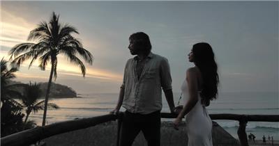 一对情侣站在海岸边望向大海