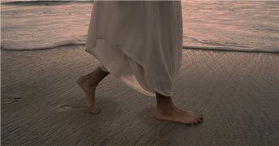 实拍女子光脚走在海滩上
