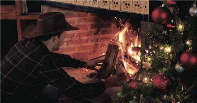圣诞节夜晚男人在壁炉里生火