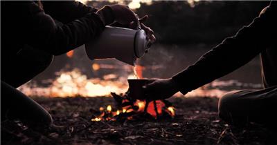 傍晚时分人们围着篝火分享热饮
