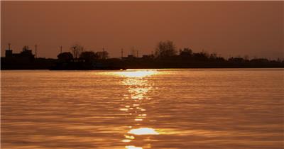 傍晚夕阳落日逆光金色水面轮船剪影